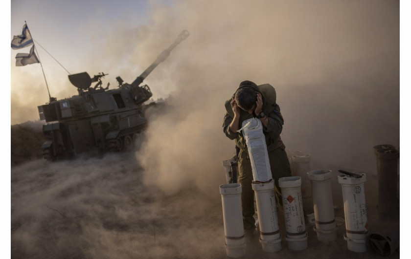 Żołnierz kryje się, gdy mobilna jednostka artyleryjska wystrzeliwuje pociski 155 mm do Strefy Gazy z Netivot w Izraelu podczas konfliktu między Izraelem a Hamasem 6 listopada 2023 r. (Zdjęcie: Amir Cohen)