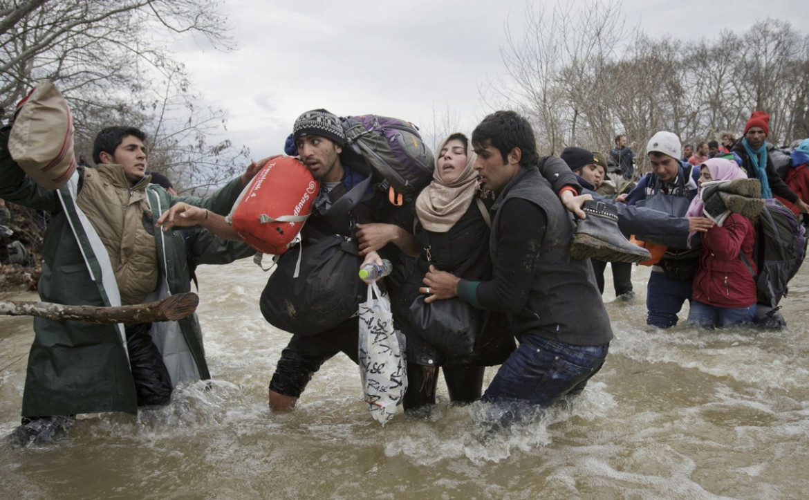 fot. Vadim Ghirda, "Migrant Crossing", 2. miejsce w kategorii Contemporary Issues / Singles.

Mężczyźni pomagają kobiecie przejść się przez rzekę w celu przedostania się z Grecji do Macedonii trasą, która omijałaby ogrodzenie na granicy.