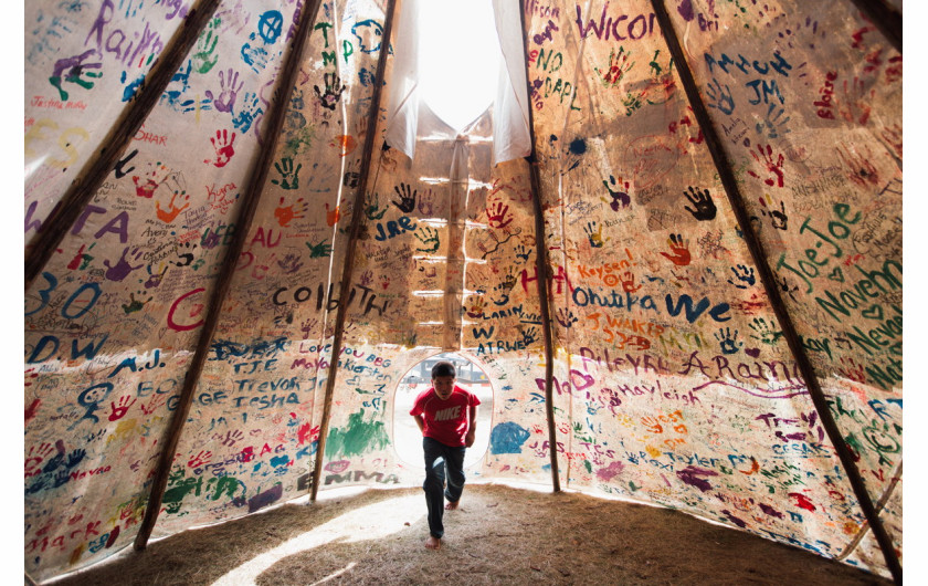 fot. Amber Bracker, Standing Rock, 1. miejsce w kategorii Contemporary Issues / Stories.

Przez prawie 10 miesięcy Siuksowie z plemienia Standing Rock zamieszkiwali w namiotach w proteście przeciwko budowie rurociągu Dakota Access Pipeline, który przebiegać miał przez ich terytorium, zagrażając ujęciom wody pitnej. Policja rozpędziła protestujących przy użyciu pojazdów wojskowych, gazu pieprzowego, armatek wodnych i gumowych kul. Mundurowi zostali też oskarżeni o znęcanie się nad aresztowanymi.