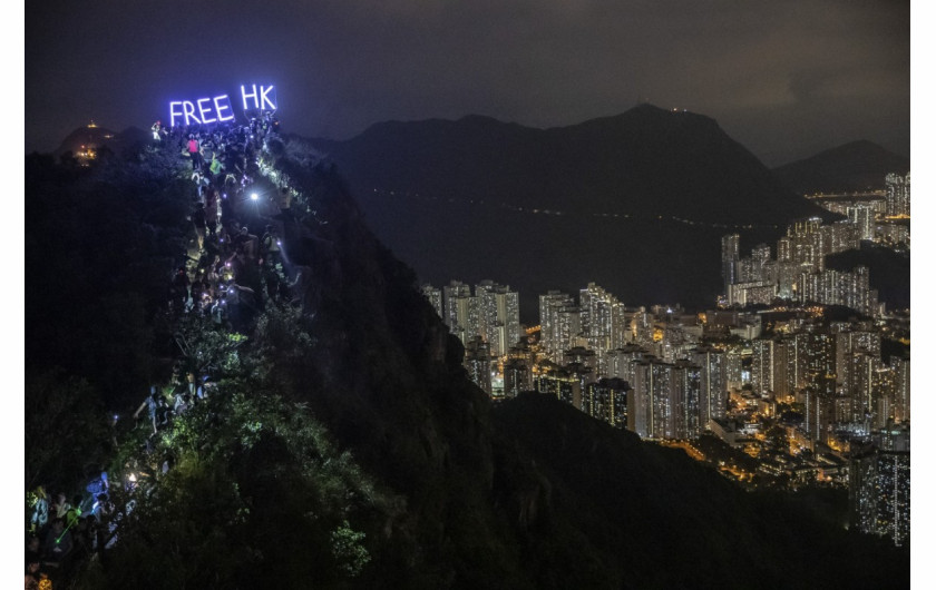 fot. Athit Perawongmetha. Setki protestujących wspina się na szczyt skały Lion Rock, na której umieszczono świecący napis nawołujący do uwolnienia Hong Kongu spod władzy Chin. 13 września 2019 / Pulitzer Prize for Breaking News Photography 2020
