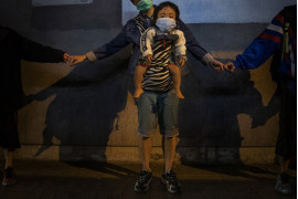 fot. Leah Millis. Dziecko w nosidełku sfotografowane podczas tworzenia "ludzkiego łańcucha" na rzecz solidarności z protestującymi w Kowloon Bay. Hong Kong, Chiny, 30 listopada 2019 /  Pulitzer Prize for Breaking News Photography 2020