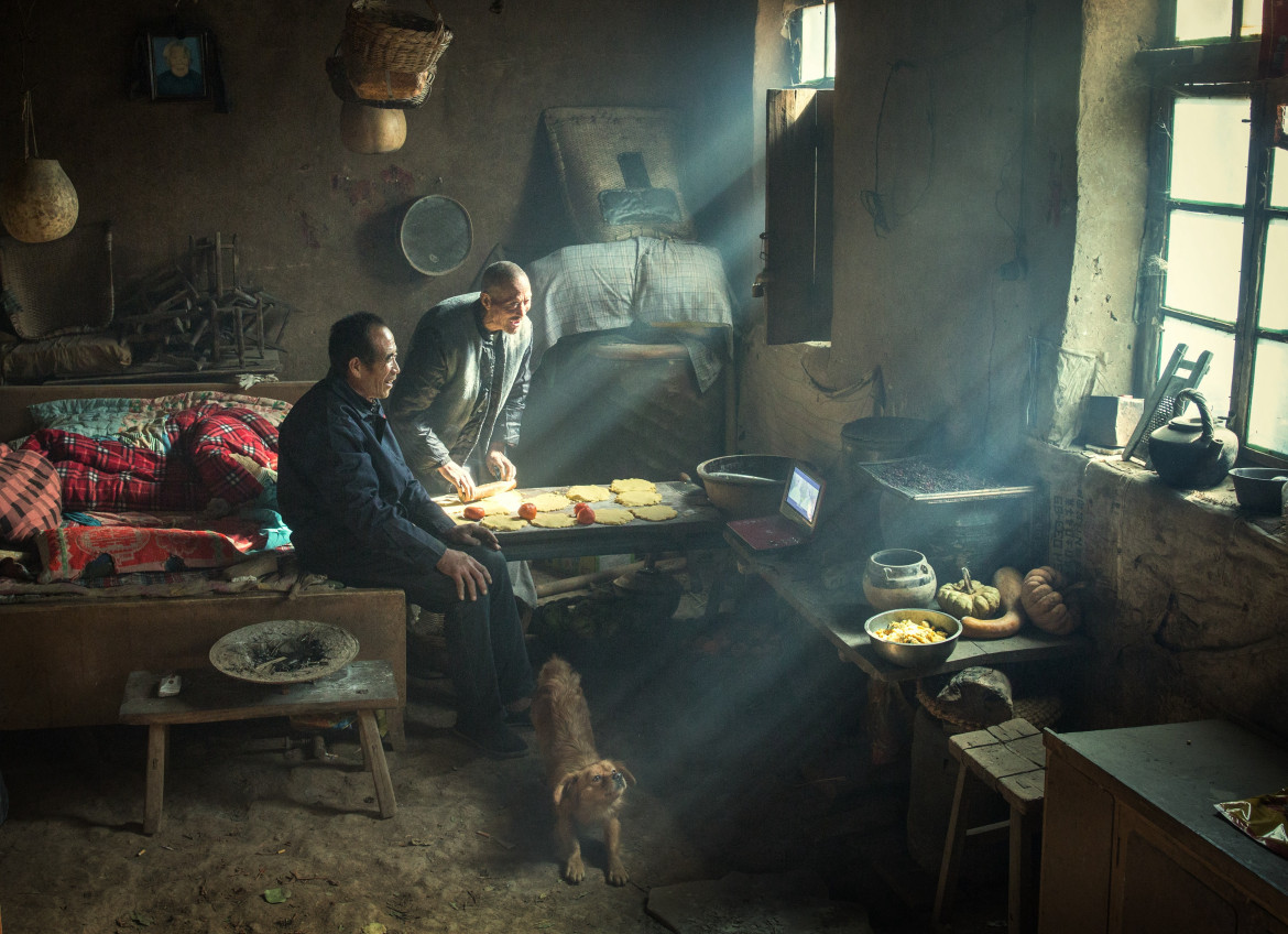 © Li Huaifeng, "Earth Kiln" - nominacja w PEOPLE SINGLES / Dwaj bracia mieszkają w tradycyjnym pomieszczeniu yaodong ("jaskini pieca"), wykutym w zboczu wzgórza na płaskowyżu lessowym w środkowych Chinach. Ściany wyłożone ziemią mają dobre właściwości izolacyjne, pozwalając mieszkańcom przetrwać mroźne zimy.