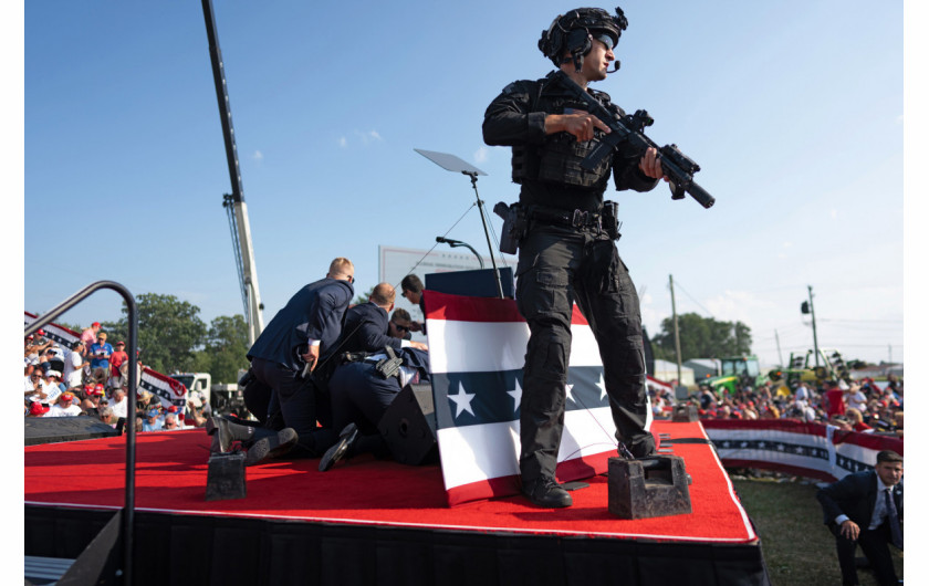 Fot. Doug Mills, The New York Times, Pulitzer Prize in Breaking News Photography 2025Po tym, jak zamachowiec otworzył ogień, agenci z Secret Service Trumpa rzucili się, by go osłaniać i chronić przed kolejnymi strzałami. Członek zespołu antysnajperskiego Secret Service zajął miejsce na scenie, przeczesując teren w poszukiwaniu strzelca i innych potencjalnych zagrożeń.