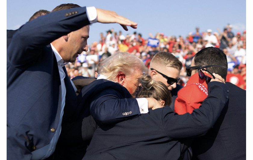 Fot. Doug Mills, The New York Times, Pulitzer Prize in Breaking News Photography 2025Na zdjęciu widać zakrwawione ucho Trumpa, gdy agenci odsuwają go od miejsca zdarzenia. Jeden z agentów wyciąga rękę nad głowę, aby zmniejszyć widoczność byłego prezydenta na wypadek, gdyby padło więcej strzałów.