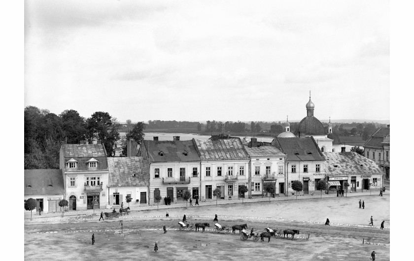 Gródek Jagielloński. Panorama rynku z widocznymi witrynami sklepów i furmankami zaprzężonymi w konie. W tle cerkiew greckokatolicka pw. Zwiastowania Najświętszej Maryi Panny, 1934 – NAC.