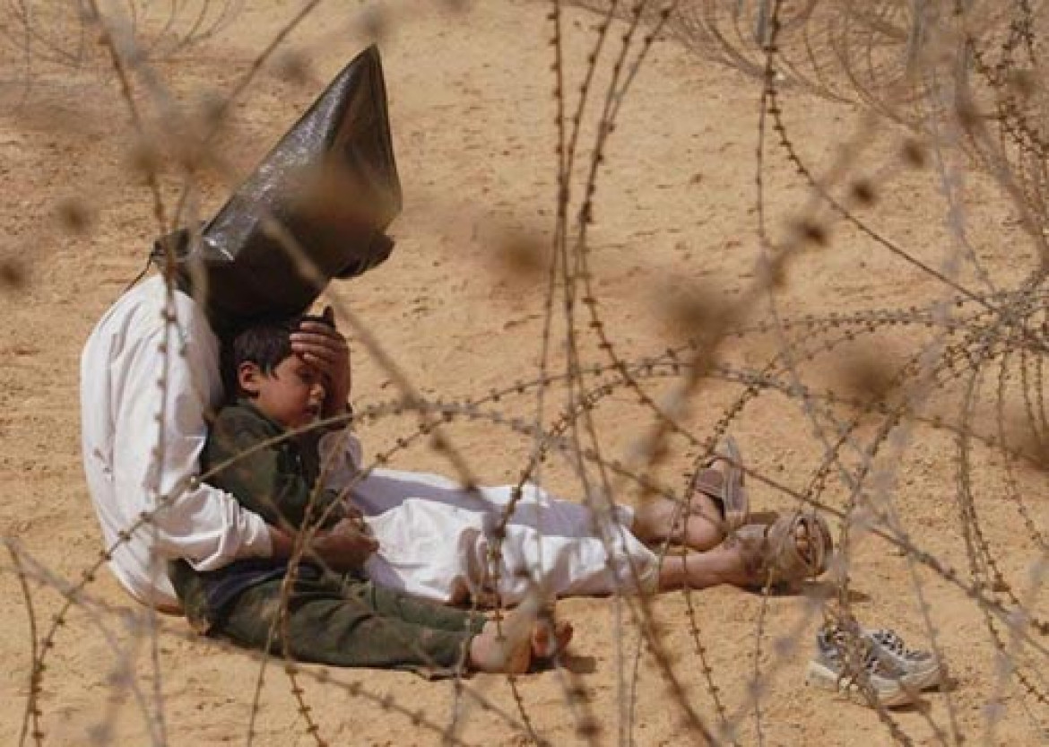 Jean-Marc Bouju, Francja, The Associated Press "Pojmany iracki mężczyzna trzymający w ramionach swojego czteroletniego synka w centrum przesiedleńczym POW, niedaleko Najafu w Iraku". 31 marca 2003