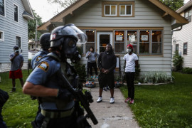 Przechodnie obserwują, jak policja idzie ulicą 28 maja 2020 r. w St. Paul w Minneapolis. (Fot. John Minchillo.) / Pulitzer Prize 2021 for Breaking News Photography