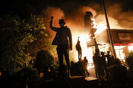 Protestujący zbierają się przed płonącą restauracją fast food, 29 maja 2020 r. w Minneapolis. (Fot. John Minchillo.) / Pulitzer Prize 2021 for Breaking News Photography 