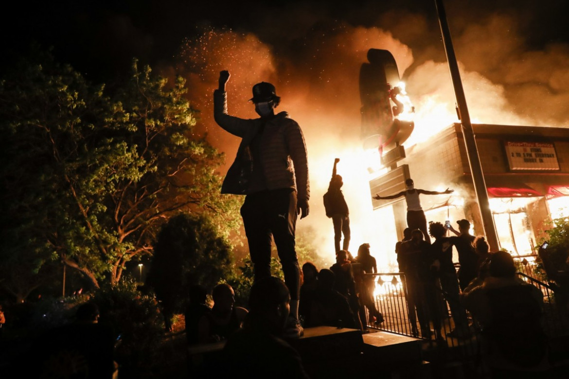 Protestujący zbierają się przed płonącą restauracją fast food, 29 maja 2020 r. w Minneapolis. (Fot. John Minchillo.) / Pulitzer Prize 2021 for Breaking News Photography 