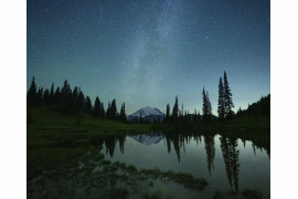 <b>W. Kent Williamson / "Pictures of the Year" National Geographic</b></br></br>
Czasami nieprzespana noc jest kluczem do wspaniałej fotografii. Około 3:40 rano w chłodny letni poranek fotograf W. Kent Williamson zrobił to zdjęcie z jeziora Tipsoo w Parku Narodowym Mount Rainier w stanie Waszyngton. Zza nieruchomej wody mógł dostrzec linię reflektorów, gdy zmęczeni wspinacze zbliżali się do szczytu o wysokości 14,411 stóp - kulminacji wielodniowej wspinaczki. "Nocne niebo było niezwykle czyste, a Droga Mleczna była widoczna tuż nad górą" - mówi Williamson. "Byłem zaskoczony widząc, jak jasne były latarki wspinaczy".

