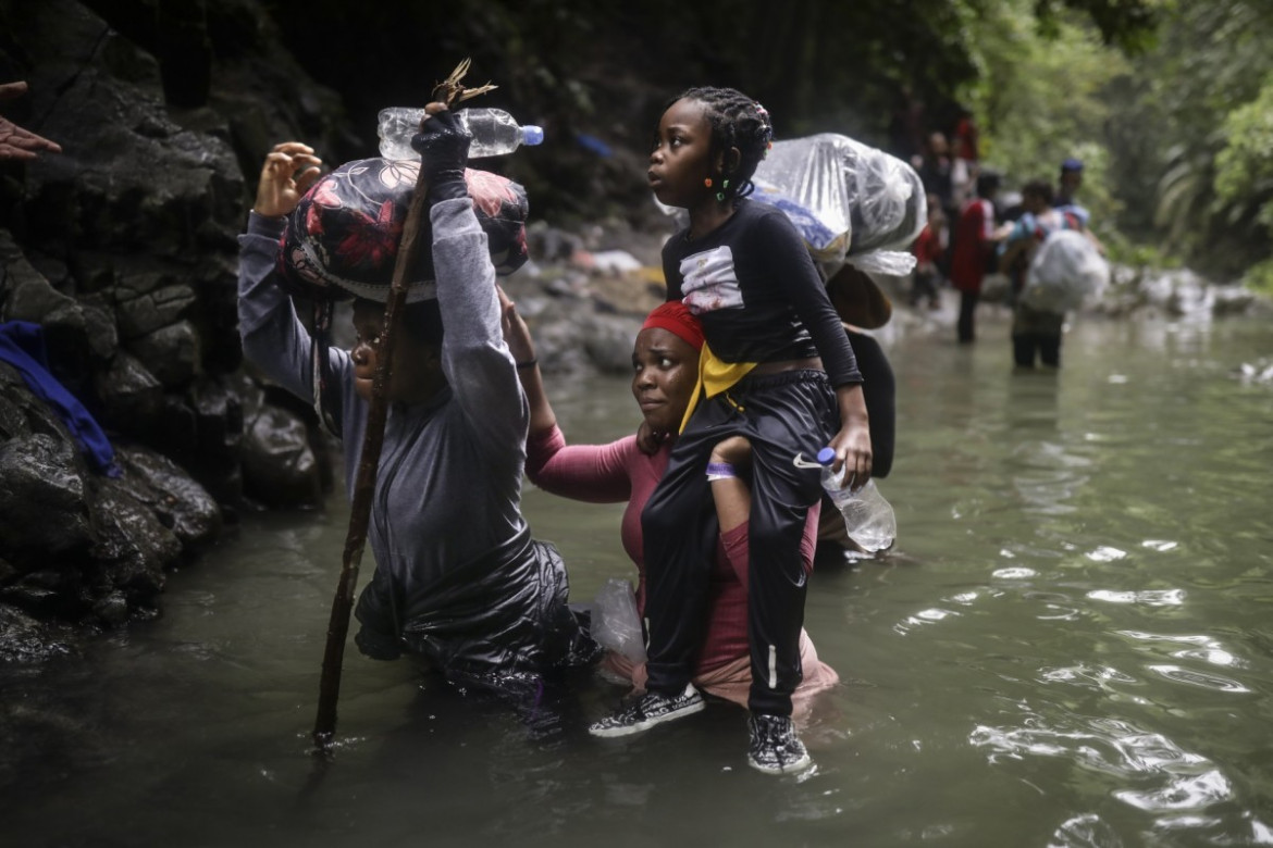 Haitańscy migranci przedzierają się przez wodę, przekraczając Darién Gap z Kolumbii do Panamy w nadziei na dotarcie do USA, wtorek, 9 maja 2023 r. (AP Photo/Ivan Valencia)
