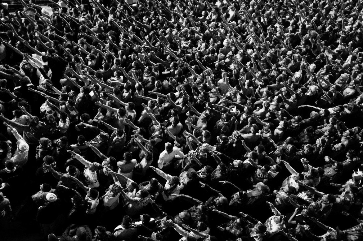 fot. Romain Laurendeau, z projektu "Kho, the Genesis of a Revolt", World Press Photo Story of the Year 2020<br></br><br></br>Według raportu UNESCO, 72% Algierczyków poniżej 30 roku życia jest bezrobotnych. Wydarzenia „Czarnego października” z 1988 r., pozostały w pamięci Algierczyków i nadal wzbudzają gniew.  Brutalnie reakcja władzy i  żniwo ponad 500 zabitych w ciągu pięciu dni zapoczątkowały okres zwany „czarną dekadą” przemocy i niepokojów. Po trzydziestu latach skutki tych wydarzeń są nadal obecne. Wysokie bezrobocie prowadzi do frustracji w codziennym życiu, a wielu młodych ludzi czuje się odłączonych od państwa i jego instytucji. W biednych dzielnicach klasy robotniczej, takich jak Bab el-Oued w Algierze, młodzi ludzie szukają schronienia w diki (prywatnych miejscach), które są dla nich „bańkami wolności”, z  dala od spojrzenia społeczeństwa i konserwatywnych wartości społecznych. Jednak to kruche poczucie wspólnoty i solidarności często nie wystarcza, aby złych warunkach życia. W lutym 2019 r. tysiące młodych ludzi z dzielnic robotniczych ponownie wyszło na ulice, co stało się ogólnokrajowym wyzwaniem pod rządami długoletniego prezydenta Abdelaziza Boutefliki.<br></br><br></br>Kho w potocznym języku Afryki oznacza „brat”. Opowiada o genezie buntu. Jest to historia głębokiego niepokoju młodych, którzy znajdują odwagę by rzucić wyzwanie dotychczasowym autorytetom i stają się inspiracją dla reszty populacji. Daje to początek największemu ruchowi protestacyjnemu w Algierii od dziesięcioleci.