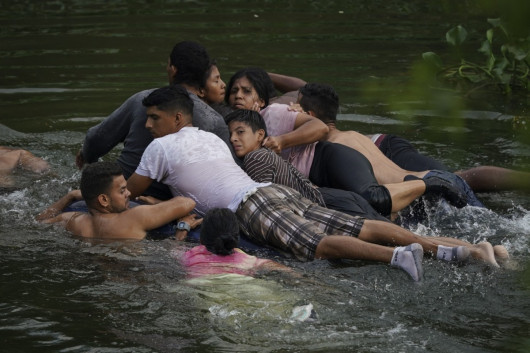 Migranci przekraczają Rio Bravo na nadmuchiwanym materacu do Stanów Zjednoczonych z Matamoros w Meksyku, 9 maja 2023 r. (AP Photo/Fernando Llano)