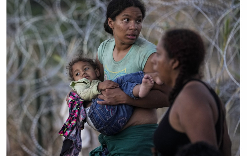 Kobieta niesie swoje dziecko po tym, jak wraz z innymi migrantami przekroczyła Rio Grande i wjechała do USA z Meksyku, aby zostać przesłuchaną przez amerykańską służbę celną i graniczną w sobotę 23 września 2023 r. w Eagle Pass w Teksasie. (AP Photo/Eric Gay)