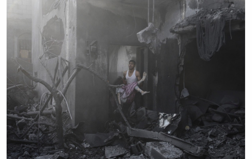 Palestyński mężczyzna wynosi ciało zmarłej kobiety spod gruzów domu zniszczonego kilka minut wcześniej przez izraelskie naloty w Khan Younis w południowej Gazie, 11 października 2023 r. (Zdjęcie: Ibraheem Abu Mustafa.)