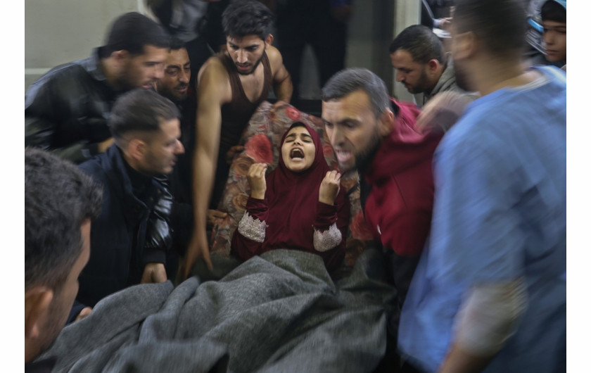 Ranna palestyńska dziewczynka krzyczy Ya Allah (O, mój Boże!), gdy jest wnoszona na noszach do szpitala Nasser, po izraelskich atakach na szkołę Ma'an, podczas konfliktu między Izraelem a Hamasem, w Khan Younis w południowej Strefie Gazy, 5 grudnia 2023 r. (Zdjęcie: Ibraheem Abu Mustafa).