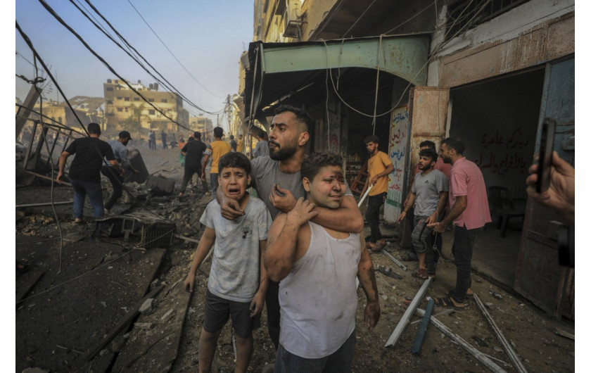 Mężczyzna trzyma swoich dwóch siostrzeńców, gdy Palestyńczycy szukają ofiar izraelskiego ataku na budynek mieszkalny w Gazie, 25 października 2023 r. (Zdjęcie: Yasser Qudih.)