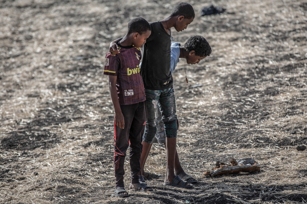 fot. Mulugeta Ayene / Associated Press<br></br><br></br>10 marca 2019 Boeing 737 MAX lotu ET302 linii Ethiopian Airlines, zniknął z radaru sześć minut po starcie z lotniska w Addis Abebie. Samolot rozbił się na polu, a wszyscy pasażerowie (157 osób) zginęli. Impet uderzenia był tak duży, że oba silniki maszyny zostały zakopane w kraterze o głębokości 10 metrów, a szczątki pasażerów były prawie niemożliwe do zidentyfikowania. 14 listopada, osiem miesięcy po katastrofie, wszystkie niezidentyfikowane szczątki ofiar pochowano w rzędach identycznych trumien. Skala katastrofy jest porównywalna z awarią takiego samego samolotu linii Lion Air, który rozbił się 12 minut po starcie z Dżakarty w październiku 2018 r. Kraje na całym świecie (początkowo z wyjątkiem USA) uziemiły wszystkie Boeingi 737 MAX. Wstępne raporty wykazały, że piloci nie byli w stanie zapobiec wielokrotnemu nurkowaniu w samolocie, pomimo przestrzegania procedur zalecanych przez Boeinga. Okazało się, że w obu przypadkach walczyli ze zautomatyzowanym systemem bezpieczeństwa, który wielokrotnie popychał nos samolotu w dół. Wstępnie ustalono, że automatyczny system wspomagania był aktywowany na skutek błędnych odczytów czujników, a interwencja systemu w takich warunkach była nieuzasadniona. Boeing dementował takie przyczyny katastrofy, ale obiecał poprawkę oprogramowania, której nie dokonano do czasu katastrofy lotu ET302. Boeingi 737 MAX pozostały uziemione do odwołania.