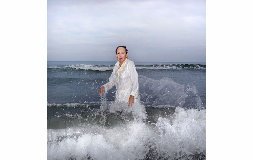 Ana Nance, „Ostatni portret Mary Kay”, North Myrtle Beach, Południowa Karolina, USA.

Na południu Stanów Zjednoczonych wciąż kultywowany jest religijny rytuał baptystycznego Chrztu. Osoba chrzczona, ubrana na biało, wchodzi do wody, by oczyścić ciało i duszę. Na zdjęciu jest moja macocha Mary Kay, którą sfotografowałam w miejscu, w którym spędziłam wiele radosnych chwil dzieciństwa. Ten portret jest też hołdem dla mojego ojca, próbą odtworzenia zdjęcia, które zrobiłam mu wiele lat temu, tuż przed jego śmiercią. Ten chrzest nie ma nic wspólnego z religią - to pielęgnowanie pamięci, miłości i wdzięczności. To mój własny rytuał. Kay również zmarła na raka w październiku tego roku. To jest jej ostatni portret.
