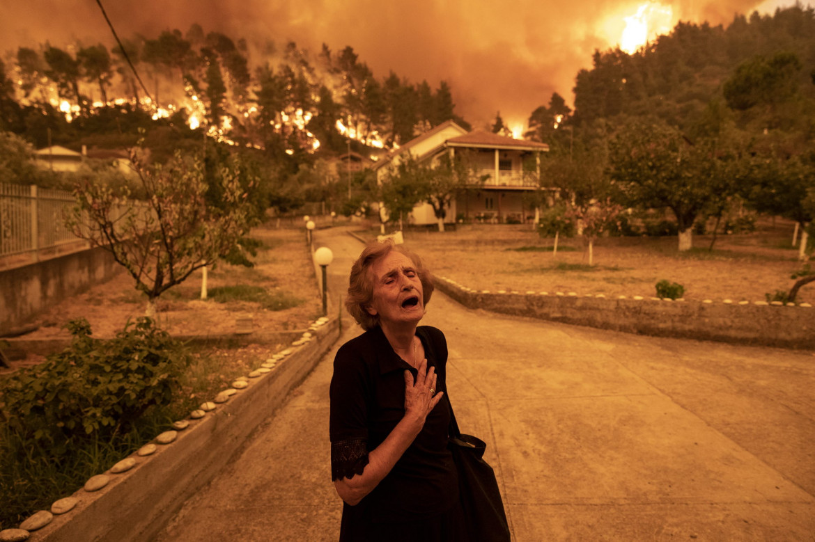 fot. Konstantinos Tsakalidis,"Evia Island Wildfire", nagroda WPP w okręgu Europejskim<br></br><br></br>Panayiota Kritsiopi wydaje okrzyk rozpaczy, gdy pożar zbliża się do jej domu w wiosce Gouves na greckiej wyspie Evia, 8 sierpnia 2021 r. „W tym momencie krzyczałem nie tylko dla siebie, ale za całą wioskę" - miała powiedzieć bohaterka zdjęcia. Koniec końców jej dom pozostał jednak nienaruszony.<br></br><br></br>
Pożary na Evii - największej greckiej wyspie po Krecie - wybuchły w lipcu i sierpniu, po największej suszy, jakiej Grecja doświadczyła od 30 lat. Zapanowanie nad nimi zajęło służbom prawie dwa tygodnie.