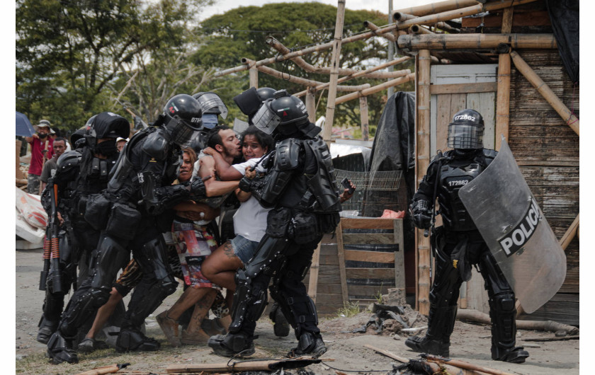 fot. Vladimir Encina, San Isidro Settlement Eviction, nagroda WPP w okręgu południowoamerykańskimOficerowie policji aresztują mężczyznę podczas eksmisji ludzi z osady San Isidro w Puerto Caldas, Risaralda, Kolumbia, 6 marca 2021 r.Eksmisje mieszkańców osiedla San Isidro rozpoczęły się 3 marca 2021 roku, przed budową linii kolejowej, która miała połączyć stolicę okręgu Risaralda z Buenaventurą - głównym portem Kolumbii na Pacyfiku. Władze powiedziały, że projekt przyniesie pracę i zrodzi nowe inwestycje na terenie, który oficjalnie nie należał do eksmitowanych ludzi. Po publikacji zdjęć Enciny i późniejszych relacjach w mediach, członkowie rządu przyznali eksmitowanym mieszkańcom San Isidro odszkodowanie i obiecali zastępcze zakwaterowanie. Do początku 2022 roku pozostawali oni jednak nadal w obozach  tymczasowych.