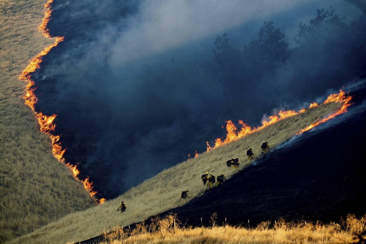fot. Noah Berger / Associated Press, "Battling the Marsh Fire". 2. nagroda w kategorii Environment<br></br><br></br> Strażacy walczą z pożarem Marsch Complex Fire nieopodal miasta Brentwood w Kaliforni, 3 sierpnia 2019 roku. Pożar rozpoczął się 3 sierpnia i pochłaniając w sumie 300 hektarów lądu. Pożary lasów są naturalnie występującym zjawiskiem w Kaliforni jednak z roku na rok rozpoczynają się one wcześniej. Naukowcy jako przyczynę podają ocieplenie klimatu. Prezydent Donal Trump stwierdził z kolei, że powodem jest złe gospodarowanie terenami leśnymi stanu Kalifornia.