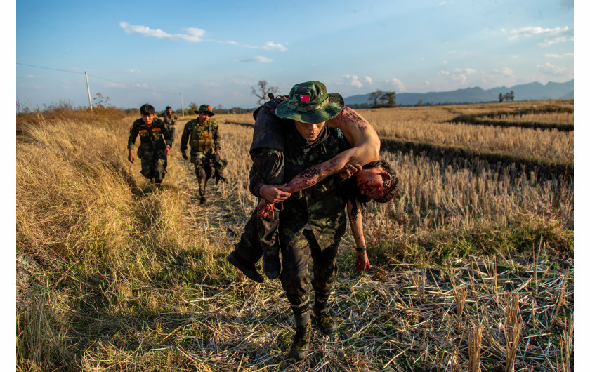 fot. Mauk Kham Wah, nominacja z regionu Azji Południowo-wschodniej i OceaniiBojownicy ruchu oporu z Ludowych Sił Obrony (PDF) wycofują się z ciałem towarzysza po starciu z birmańskim wojskiem w Moe Bye, Birma, 21 lutego 2022 r. Władze Birmy wysłały do tego regionu posiłki w związku z nasileniem się walk z lokalnymi grupami opozycyjnymi.

PDF walczy u boku regionalnych i etnicznych grup zbrojnych sprzeciwiających się dyktaturze wojskowej. Jest to zbrojne skrzydło równoległego rządu, który został utworzony głównie przez obalonych demokratycznych ustawodawców w następstwie wojskowego zamachu stanu w Myanmarze w 2021 roku. Z wielkim osobistym ryzykiem fotograf spędził rok z ludźmi, którzy dołączyli do ruchu oporu.