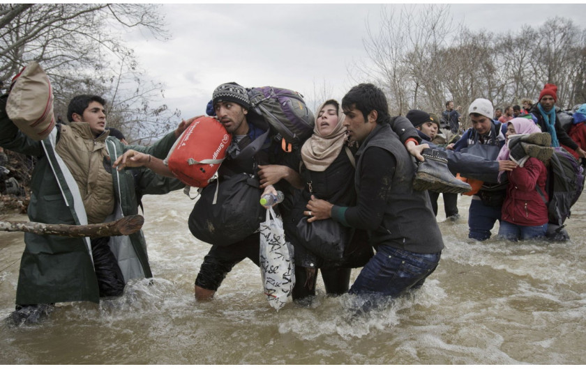 fot. Vadim Ghirda, Migrant Crossing, 2. miejsce w kategorii Contemporary Issues / Singles.

Mężczyźni pomagają kobiecie przejść się przez rzekę w celu przedostania się z Grecji do Macedonii trasą, która omijałaby ogrodzenie na granicy.