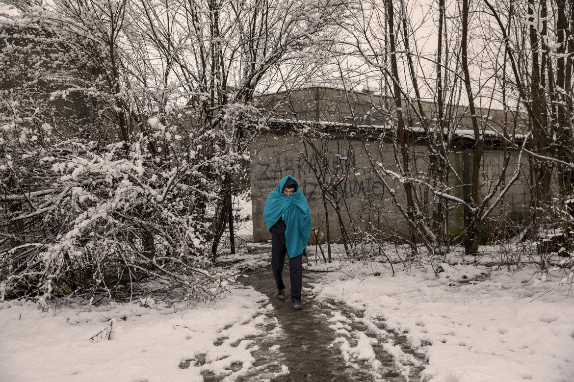 fot. Alessio Paduano, Migrant przemierza pokryte śniegiem pola w pobliżu opuszczonej fabryki w Bihacu w Bośni i Hercegowinie, 26 stycznia, 2021 r. Wielu migrantów unika przebywania w oficjalnych bośniackich obozach dla uchodźców z powodu trudnych warunków, w jakich są zmuszeni żyć, a także dlatego, że nie mogą z nich swobodnie wychodzić.