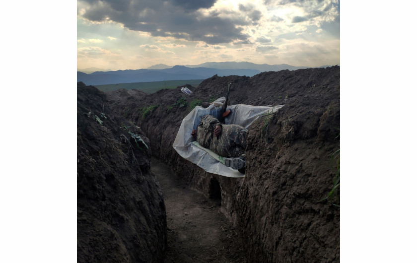 fot. Vaghinak Ghazaryan, Armenia, Resting Soldier, 3 miejsce w kategorii Contemporary issues - zdjęcie pojedyncze / World Press Photo 2021Żołnierz leży w rowie, wsparty na plastikowej osłonie, w północno-wschodniej części Syunikin, Armenia, 31 października 2020.Druga wojna o Górski Karabach rozpoczęła się 27 września, a konflikt trwał do 9 listopada. Był to największy konflikt między Armenią a Azerbejdżanem o sporne terytorium od lat 90 XX wieku. Pierwsza wojna zakończyła się niełatwym zawieszeniem broni, w wyniku którego zwycięscy Ormianie jednostronnie ogłosili niepodległość i wypędzili około 800 000 Azerów na wygnanie.W ciągu ostatnich 30 lat niewiele zrobiono, aby rozwiązać kwestię Górskiego Karabachu, który nadal był uznawany na arenie międzynarodowej za należący do Azerbejdżanu, a między obiema stronami dochodziło do okresowych starć zbrojnych, które w 2020 r. przerodziły się w wojnę.Dzięki Rosji w listopadzie Azerbejdżan odzyskał terytorium utracone w latach 90., ale stolica regionu Stepanakert pozostała pod kontrolą Armenii. Armia armeńska stopniowo wycofywała się z regionu Górskiego Karabachu, by zastąpić ją rosyjskimi siłami pokojowymi, które będą tam rozmieszczone do 2025 roku.