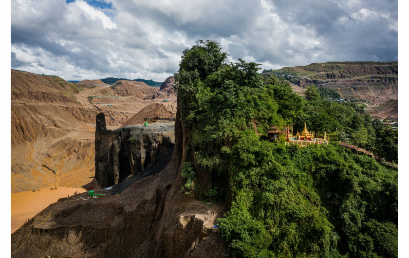 fot. Hkun Lat, Birma, Temple and Half-Mountain, nominacja w kategorii Środowisko - zdjęcie pojedyncze / World Press Photo 2021Świątynia buddyjska zajmuje połowę góry, podczas gdy druga połowa została rozkuta przez ciężkie maszyny wydobywające jadeit w Hpakant w stanie Kaczin w Birmie, 15 lipca 2020 r.Hpakant to miejsce, w którym znajduje się największa na świecie kopalnia jadeitu. Przemysł napędzają Chiny, gdzie jadeit jest popularnym symbolem statusu. Firma Global Witness poinformowała, że ​​tylko w 2014 roku rynek jadeitu w Birmie był wart 31 miliardów dolarów - prawie połowę PKB kraju - i że sektor ten wydawał się być kontrolowany przez sieci elit wojskowych oraz handlarzy narkotyków.Rząd Narodowej Ligi na rzecz Demokracji (NLD) obiecał rozwiązać problemy w tym sektorze, ale postępy są powolne. Firmy nie spełniają wymogów rządowych, aby przeprowadzić ocenę oddziaływania na środowisko zgodnie z międzynarodowymi standardami, a urzędnicy rzekomo mają związane ręce.Niszczenie środowiska przez działalność górniczą obejmuje m.in. masową utratę roślinności, degradację gruntów rolnych oraz zanieczyszczanie rzek i jest głównie wynikiem niewłaściwych praktyk górniczych. W Hpakant problem potęgują wysokie hałdy odpadów wydobywczych, rozległe opuszczone wyrobiska oraz firmy, które nie potrafią ustabilizować głębokich wykopów. Osuwiska, takie jak lawina błotna w lipcu 2020 r., w której zginęło co najmniej 100 osób nie należą do rzadkości.