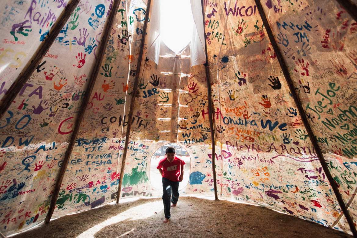 fot. Amber Bracker, "Standing Rock", 1. miejsce w kategorii Contemporary Issues / Stories.
Przez prawie 10 miesięcy Siuksowie z plemienia Standing Rock zamieszkiwali w namiotach w proteście przeciwko budowie rurociągu Dakota Access Pipeline, który przebiegać miał przez ich terytorium, zagrażając ujęciom wody pitnej. Policja rozpędziła protestujących przy użyciu pojazdów wojskowych, gazu pieprzowego, armatek wodnych i gumowych kul. Mundurowi zostali też oskarżeni o znęcanie się nad aresztowanymi.