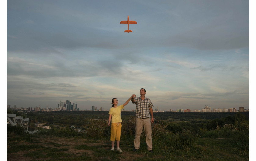 fot. Tatiana Nikitina, Rosja, In Flight, 3 miejsce w kategorii Portret - zdjęcie pojedyncze / World Press Photo 2021Ojciec uczy swoją autystyczną córkę Ksenię (10 l.), jak uruchomić zabawkowy samolot w Moskwie, w Rosji, 23 sierpnia 2020 r.Zaburzenia ze spektrum autyzmu (ASD) to zaburzenie rozwojowe, które wpływają na komunikację i zachowanie. Nazywa się to zaburzeniem „spektrum”, ponieważ istnieje duże zróżnicowanie w rodzaju i nasileniu objawów, których doświadczają ludzie. Osoby ze spektrum autyzmu mogą mieć trudności z komunikacją i interakcją z innymi ludźmi, wykazywać ograniczone zainteresowania i powtarzające się zachowania oraz mogą reagować impulsywnie na bodźce środowiskowe, co oznacza, że ​​może im być trudniej dobrze funkcjonować w pracy, szkole lub w szkole.Pojęcie autyzmu jest w Rosji całkiem nowe, często występuje negatywny stosunek do osób z takimi zaburzeniami zachowania. Niewielu lekarzy i nie-lekarzy jest zaznajomionych z autyzmem i często jest on błędnie diagnozowany. Rodzice dzieci z ASD mogą mieć trudności ze znalezieniem programów wsparcia.