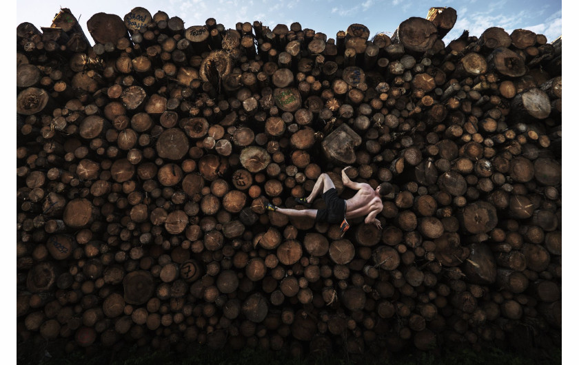 fot. Adam Pretty, Australia, Log Pile Bouldering, nominacja w kategorii Sport - zdjęcie pojedynczeGeorg wspina się na stos drewna podczas treningu boulderingu w Kochel am See w Bawarii, w Niemczech, 15 września 2020 r.Bouldering polega na wspinaniu się po małych formacjach skalnych i głazach o wysokości zwykle nie większej niż sześć metrów, bez lin i uprzęży. Historycznie rzecz biorąc, wszystko zaczęło się jako trening do bardziej ambitnych wspinaczek, ale przekształciło się w osobny sport. Siłownie wspinaczkowe i obiekty sportowe w Monachium zostały zamknięte w wyniku trwającej pandemii COVID-19, więc sportowcy musieli wykazać się kreatywnością w swoich metodach treningowych.