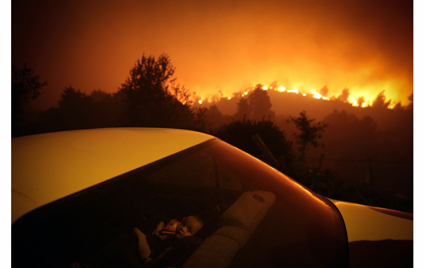 fot. Nuno André Ferreira, Portugalia, Forest Fire, nominacja w kategorii Spot news - zdjęcie pojedyncze / World Press Photo 2021Dziecko siedzi w samochodzie nieopodal pożaru lasu w Oliveira de Frades, w Portugalii, 7 września 2020 r.Pożar w Oliveira de Frades, około 100 kilometrów od Porto we wschodniej Portugalii, wybuchł 7 września i rozprzestrzenił się około 30 kilometrów na zachód 40 kilometrów na południowy zachód w sąsiednim okręgu. Co najmniej 300 strażaków, 100 pojazdów lądowych i 10 samolotów strażackich walczyło z pożarem w krajobrazie zdominowanym przez drzewa eukaliptusowe.Niekontrolowane rozprzestrzenianie się drzew eukaliptusowych - które dostarczają surowca dla ważnego gospodarczo przemysłu celulozowego, ale które są wyjątkowo łatwopalne - są głównym czynnikiem szybkiego rozprzestrzeniania się pożarów. W Portugalii okres pożarów trwa od czerwca do września. Gorący klimat, stałe ciepłe wiatry znad Atlantyku i dobrze zalesiony krajobraz sprawiają, że region ten jest szczególnie podatny na pożary.Ekstremalne temperatury i dotkliwa susza przyczyniły się do pożarów w2020. W raporcie opublikowanym wspólnie przez Portugalskie Stowarzyszenie Przyrody i Światowy Fundusz na rzecz Przyrody stwierdzono, że Portugalia jest najbardziej dotkniętym pożarami krajem europejskim: każdego roku spala się ponad trzy procent lasów.