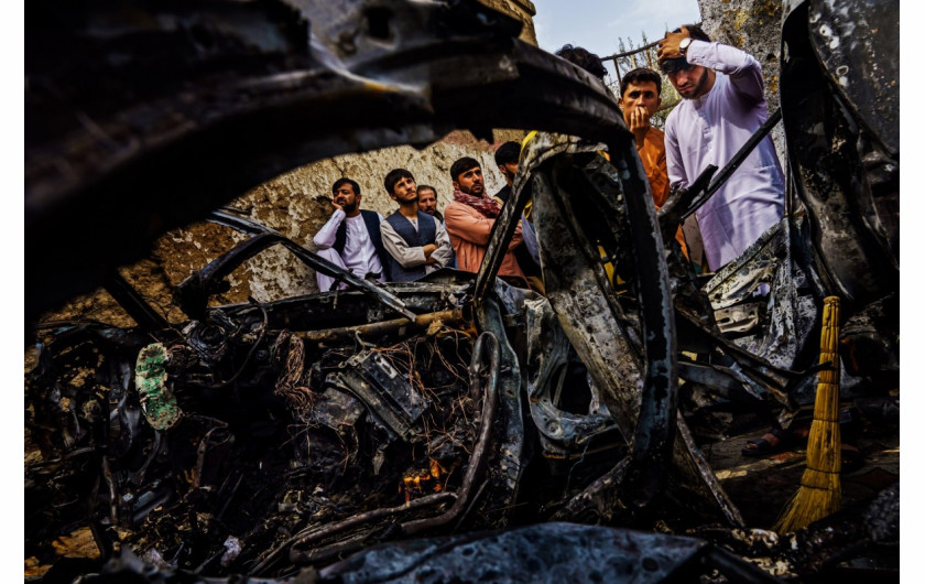 fot. Marcus Yam / LA Times, Członkowie i sąsiedzi rodziny Ahmadi zbierają się, aby obejrzeć szczątki samochodu uderzonego pociskiem przez amerykańskiego drona w dzielnicy Khwaja Burgha w Kabulu w Afganistanie, 30 sierpnia 2021 r. Amerykańskie wojsko twierdzi, że nalot miał na celu wyeliminowanie bojowników ISIS-K i odwet za zamach na lotnisko przeprowadzony przez grupę terrorystyczną. Zamiast tego zginęło 10 cywilów – członków rodziny Emala Ahmadi, w tym siedmioro dzieci. / Pulitzer Prize 2021 for Breaking News Photography  