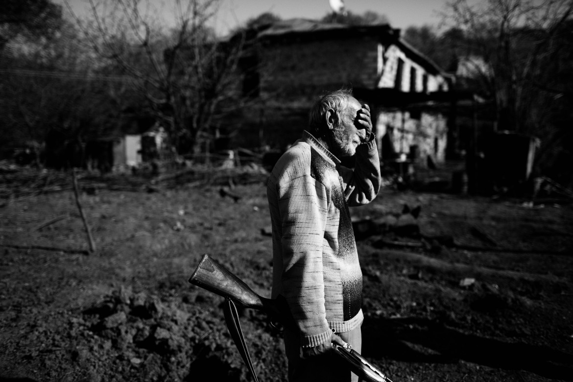 fot. Maciej Stanik, Jurij Melkumjan, lat 64, stoi przed zrujnowanym domem, który został ostrzelany w nocy z 16 na 17 października. W wyniku ostrzału jego syn został ranny, Shosh, 27 października, 2020 r 