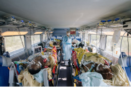fot. Laurence Geai, Francja, z cyklu: "COVID-19 Pandemic in France", 3 miejsce w kategorii "General news - seria zdjęć" / World Press Photo 2021<br></br><br></br>

Pierwsze potwierdzone przypadki zachorowań na COVID-19 w Europie odnotowano we Francji w dniu 24 stycznia. Szybko pojawiły się doniesienia o zakażeniach w innych krajach europejskich, a 13 marca Światowa Organizacja Zdrowia ogłosiła Europę epicentrum pandemii. Do końca marca w Paryżu i na jego przedmieściach odnotowano ponad jedną czwartą z 29 000 potwierdzonych zakażeń we francuskich szpitalach, z czego 1300 osób przebywało na intensywnej terapii. Między 17 marca a 11 maja Francja ogłosiła lockdown, a ograniczenia w Paryżu przedłużono do 14 czerwca. Zamknięto szkoły, kawiarnie, restauracje, sklepy i budynki użyteczności publicznej, a osoby przebywające poza domem musiały mieć przy sobie dowód tożsamości i podpisane oświadczenie o podróżowaniu. Domy opieki zostały zamknięte dla odwiedzających. Hospitalizacje osiągnęły szczyt w kwietniu, kiedy to 7,148 osób znalazło się na intensywnej terapii, podczas gdy pojemność oddziałów wynosiła tylko 5,000. Specjalnie przystosowane pociągi przewoziły pacjentów z przepełnionych szpitali do regionów, w których było mniej przypadków, a francuskie wojsko lotnicze przewoziło krytyczne przypadki ze wschodniej Francji do szpitali w sąsiednich krajach. W miarę wzrostu liczby zgonów kostnice zapełniały się po brzegi, a w miejscach takich jak hala chłodnicza paryskiego rynku hurtowego żywności Rungis otwierano doraźne kostnice. Domom pogrzebowym nakazano natychmiastowe pochowanie lub skremowanie ciał, bez żadnych ceremonii pogrzebowych, bez niczyjej obecności.
