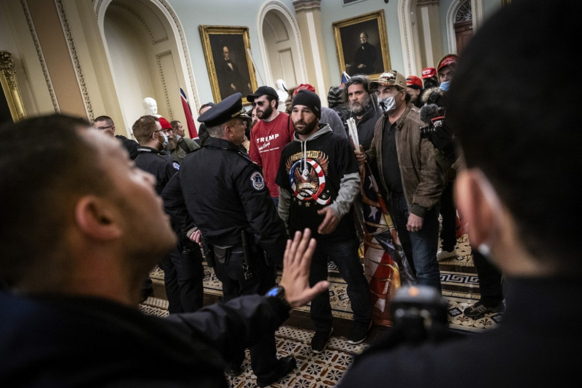 Zwolennicy prezydenta USA Donalda Trumpa konfrontują się z członkami policji Kapitolu przed salą senacką, wkrótce po włamaniu, 6 stycznia 2021 r. w Waszyngtonie. fot. Win McNamee, Getty Images / Pulitzer Prize 2021 for Breaking News Photography