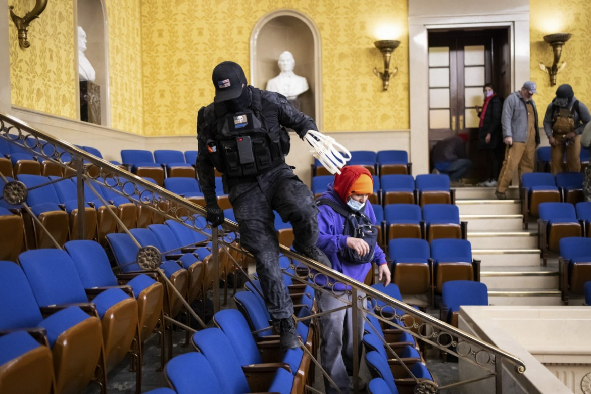 Członek tłumu, który zaatakował Kapitol niesie plastikowe kajdanki w Izbie Senatu USA, wkrótce po szturmie, 6 stycznia 2021 r. w Waszyngtonie. fot. Win McNamee, Getty Images / Pulitzer Prize 2021 for Breaking News Photography