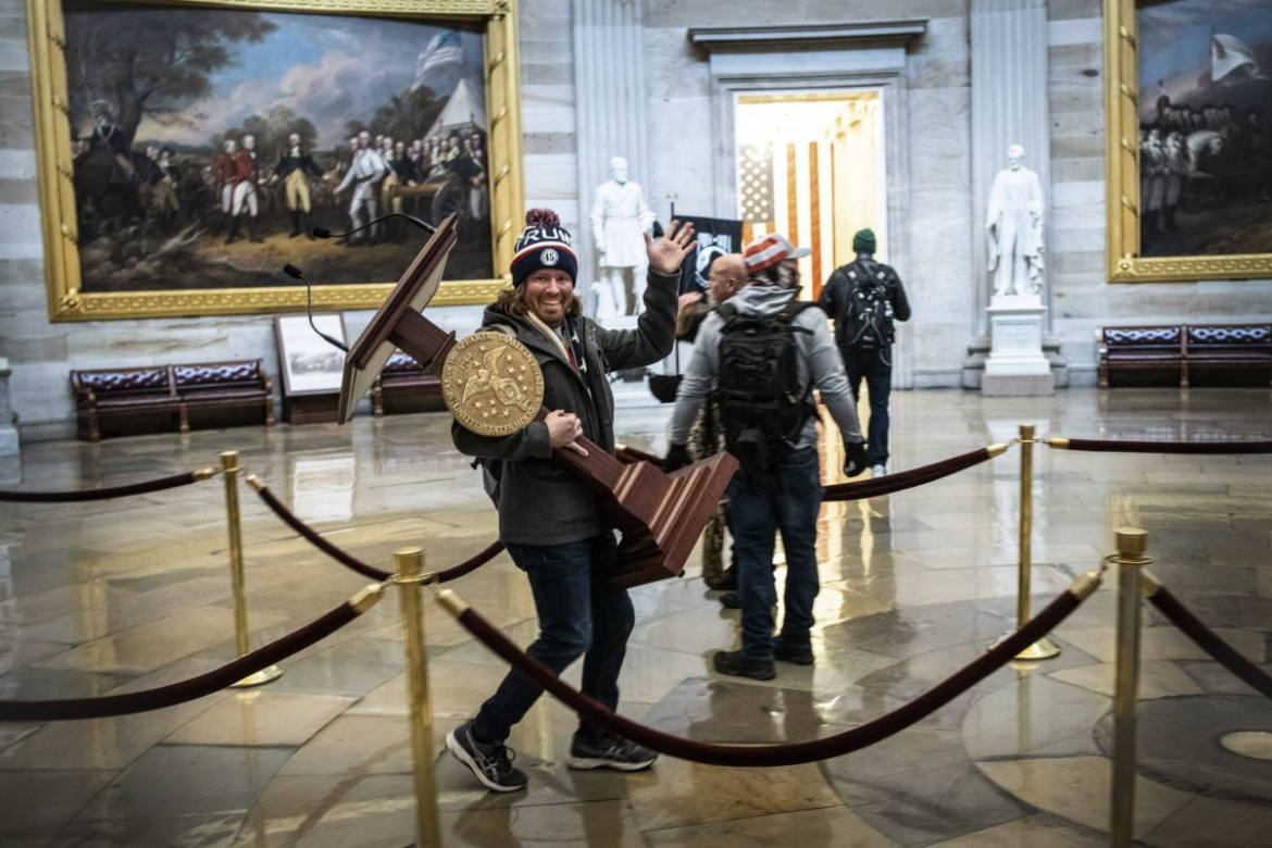 Adam Johnson niesie mównicę należącą do przewodniczącej Nancy Pelosi przez Rotundę Kapitolu, 6 stycznia 2021 r. W Waszyngtonie. fot. Win McNamee, Getty Images / Pulitzer Prize 2021 for Breaking News Photography