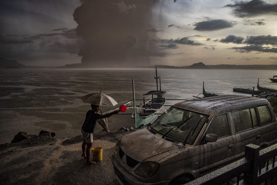 fot. Ezra Acayan, Filipiny, z cyklu: "Taal Volcano Eruption", 2 miejsce w kategorii "Przyroda - seria zdjęć" / World Press Photo 2021
<br></br><br></br>

Wulkan Taal, w prowincji Batangas, na wyspie Luzon na Filipinach, rozpoczął erupcję 12 stycznia, wyrzucając popiół na wysokość do 14 kilometrów w powietrze. Wulkan wygenerował opady popiołu i burze wulkaniczne, zmuszając do ewakuacji okolicznych mieszkańców. Erupcja przeszła w erupcję magmową, charakteryzującą się fontanną lawy z grzmotami i błyskawicami. Według Departamentu Opieki Społecznej i Rozwoju, erupcja dotknęła w sumie 212 908 rodzin, czyli prawie 750 000 osób. Szkody wyrządzone w infrastrukturze i źródłach utrzymania, takich jak rolnictwo, rybołówstwo i turystyka, zostały oszacowane na około 70 milionów dolarów. Wulkan Taal znajduje się w dużej kalderze wypełnionej przez jezioro Taal i jest jednym z najbardziej aktywnych wulkanów w kraju. Jest to "wulkan złożony", co oznacza, że nie posiada jednego otworu wylotowego lub stożka, ale kilka punktów erupcji, które zmieniały się w czasie. Taal miał 34 zarejestrowane historyczne erupcje w ciągu ostatnich 450 lat, ostatnio w 1977 roku. Podobnie jak inne wulkany na Filipinach, Taal jest częścią Pacyficznego Pierścienia Ognia, strefy o dużej aktywności sejsmicznej, w której znajdują się jedne z najbardziej aktywnych linii uskoków na świecie.