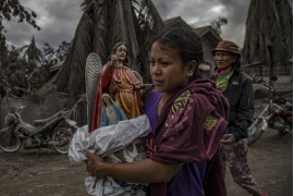 fot. Ezra Acayan, Filipiny, z cyklu: "Taal Volcano Eruption", nominacja w kategorii "Przyroda - seria zdjęć" / World Press Photo 2021
<br></br><br></br>

Wulkan Taal, w prowincji Batangas, na wyspie Luzon na Filipinach, rozpoczął erupcję 12 stycznia, wyrzucając popiół na wysokość do 14 kilometrów w powietrze. Wulkan wygenerował opady popiołu i burze wulkaniczne, zmuszając do ewakuacji okolicznych mieszkańców. Erupcja przeszła w erupcję magmową, charakteryzującą się fontanną lawy z grzmotami i błyskawicami. Według Departamentu Opieki Społecznej i Rozwoju, erupcja dotknęła w sumie 212 908 rodzin, czyli prawie 750 000 osób. Szkody wyrządzone w infrastrukturze i źródłach utrzymania, takich jak rolnictwo, rybołówstwo i turystyka, zostały oszacowane na około 70 milionów dolarów. Wulkan Taal znajduje się w dużej kalderze wypełnionej przez jezioro Taal i jest jednym z najbardziej aktywnych wulkanów w kraju. Jest to "wulkan złożony", co oznacza, że nie posiada jednego otworu wylotowego lub stożka, ale kilka punktów erupcji, które zmieniały się w czasie. Taal miał 34 zarejestrowane historyczne erupcje w ciągu ostatnich 450 lat, ostatnio w 1977 roku. Podobnie jak inne wulkany na Filipinach, Taal jest częścią Pacyficznego Pierścienia Ognia, strefy o dużej aktywności sejsmicznej, w której znajdują się jedne z najbardziej aktywnych linii uskoków na świecie.