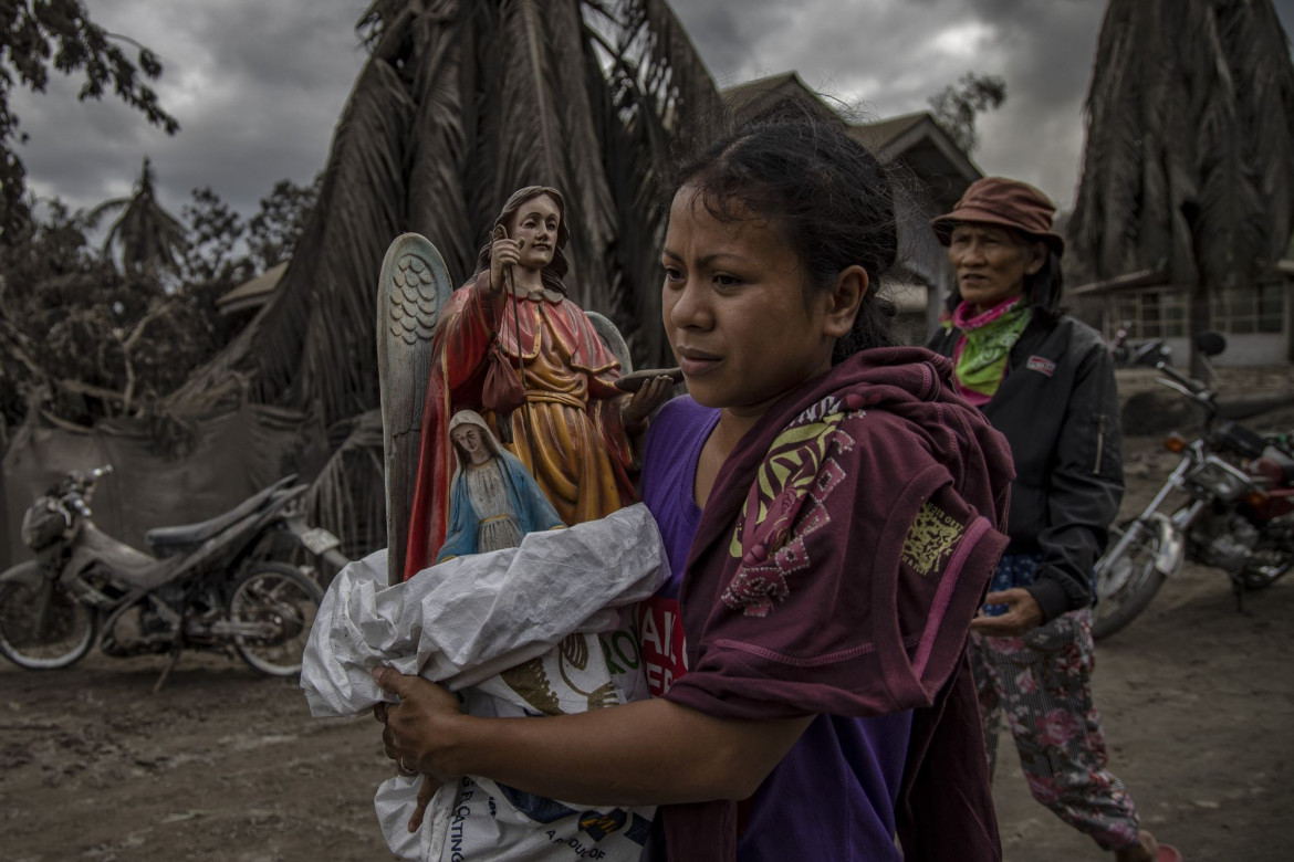 fot. Ezra Acayan, Filipiny, z cyklu: "Taal Volcano Eruption", nominacja w kategorii "Przyroda - seria zdjęć" / World Press Photo 2021
<br></br><br></br>
Wulkan Taal, w prowincji Batangas, na wyspie Luzon na Filipinach, rozpoczął erupcję 12 stycznia, wyrzucając popiół na wysokość do 14 kilometrów w powietrze. Wulkan wygenerował opady popiołu i burze wulkaniczne, zmuszając do ewakuacji okolicznych mieszkańców. Erupcja przeszła w erupcję magmową, charakteryzującą się fontanną lawy z grzmotami i błyskawicami. Według Departamentu Opieki Społecznej i Rozwoju, erupcja dotknęła w sumie 212 908 rodzin, czyli prawie 750 000 osób. Szkody wyrządzone w infrastrukturze i źródłach utrzymania, takich jak rolnictwo, rybołówstwo i turystyka, zostały oszacowane na około 70 milionów dolarów. Wulkan Taal znajduje się w dużej kalderze wypełnionej przez jezioro Taal i jest jednym z najbardziej aktywnych wulkanów w kraju. Jest to "wulkan złożony", co oznacza, że nie posiada jednego otworu wylotowego lub stożka, ale kilka punktów erupcji, które zmieniały się w czasie. Taal miał 34 zarejestrowane historyczne erupcje w ciągu ostatnich 450 lat, ostatnio w 1977 roku. Podobnie jak inne wulkany na Filipinach, Taal jest częścią Pacyficznego Pierścienia Ognia, strefy o dużej aktywności sejsmicznej, w której znajdują się jedne z najbardziej aktywnych linii uskoków na świecie.