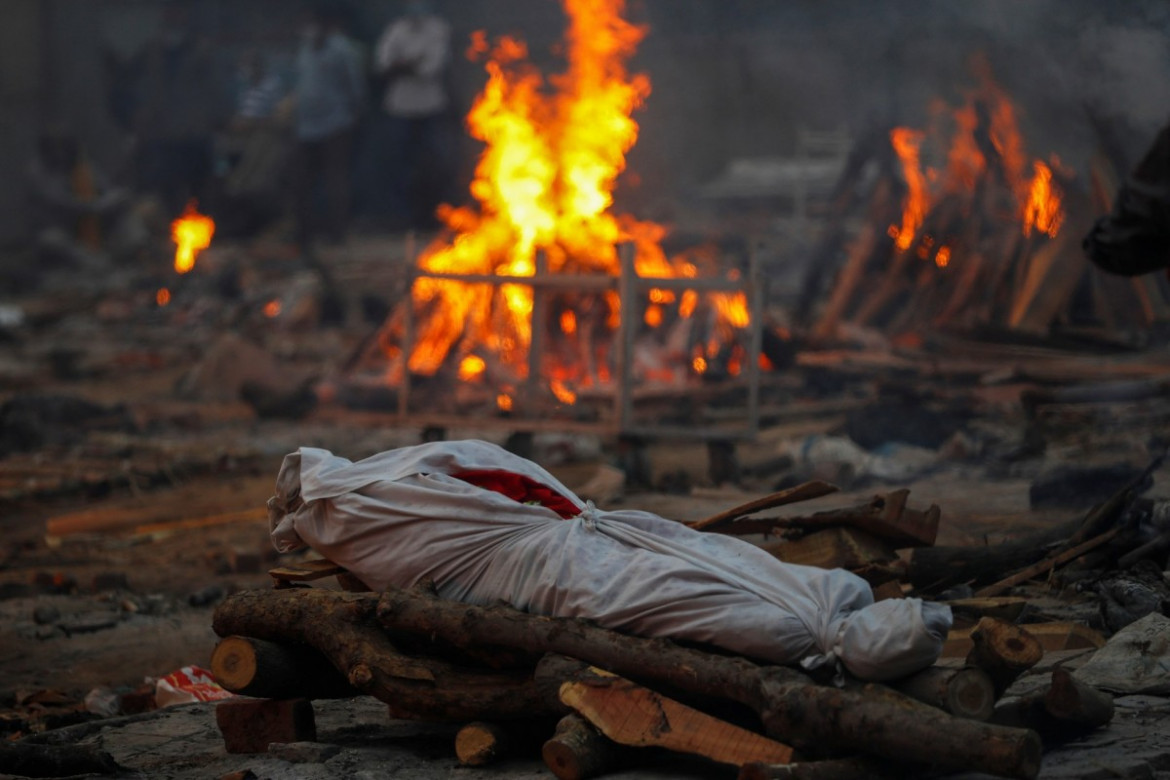 Ciało osoby zmarłej na koronawirusa leży na stosie pogrzebowym podczas masowej kremacji w krematorium w New Delhi w Indiach 1 maja 2021 r. fot. Adnan Abidi, Reuters / The Pulitzer Prize 2021 for Feature Photography