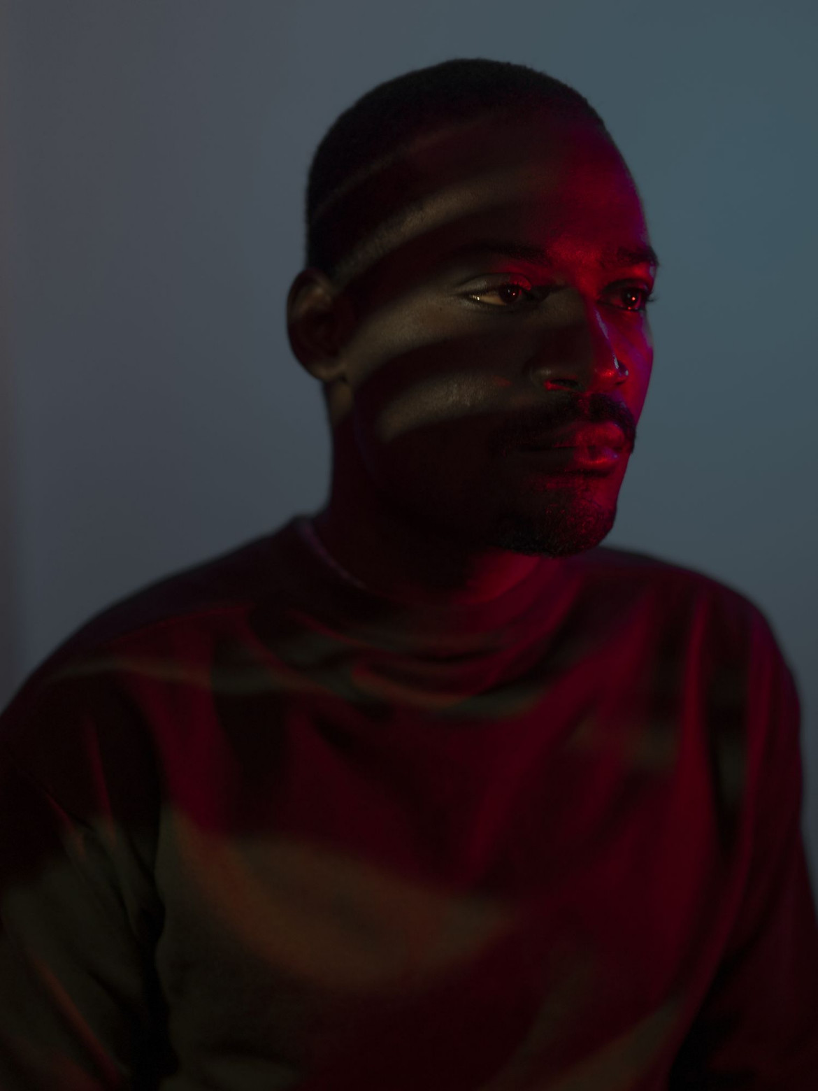 fot. Alisa Martynova, Rosja, z cyklu: "Nowhere Near", nominacja w kategorii "Portret - seria zdjęć" / World Press Photo 2021
<br></br><br></br>
We Włoszech oficjalnie przebywa ponad milion imigrantów z Afryki, a także nieznana liczba nielegalnych imigrantów, z których wielu przebyło niebezpieczną i często zagrażającą życiu drogę, aby się tam dostać. Fotograf porównuje migrantów we Włoszech do rozproszonych gwiazd, konstelacji młodych ludzi z różnych krajów, różnej płci i o różnych cechach. Wszyscy oni przybyli do Włoch z różnych osobistych powodów i są celebrowani za swoje indywidualne historie, w sposób, który stara się przeciwstawić stereotypom afrykańskich migrantów. Badanie przeprowadzone w 2016 roku przez Międzynarodową Organizację Migrantów wskazało na brak bezpieczeństwa, konflikty i dyskryminację jako główne czynniki napędzające migrację, a nie tylko powody ekonomiczne i zawodowe. Dyskryminacja ze względu na grupę społeczną, religię lub orientację seksualną została wymieniona przez prawie połowę badanej grupy. W październiku 2020 r. włoski rząd przyjął dekret unieważniający wiele z antyimigracyjnych polityk wprowadzonych przez poprzedniego ministra spraw wewnętrznych Matteo Salviniego, lidera prawicowej Lega Nord (Liga Północna).