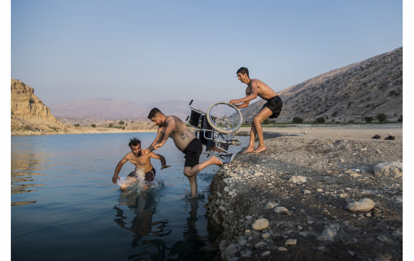 fot. Fereshteh Eslahi, Iran, Podium Photos, z cyklu: Thoughts of Flight, nominacja w kategorii Sport - seria zdjęć / World Press Photo 2021

Saeed Ramin jest zawodowym traceurem (uprawiającym parkour) mieszkającym w Gachsaran w Iranie. Siedem lat temu Saeed upadł podczas zawodów w parkourze, uszkadzając rdzeń kręgowy w szyi. Celem parkour jest przedostanie się z jednego punktu do drugiego w złożonym - zazwyczaj miejskim - otoczeniu, bez pomocy sprzętu pomocniczego, w jak najszybszy i najbardziej efektywny sposób: biegając, huśtając, wspinając się i wykonując wiele innych ruchów, czasem w niebezpiecznych sytuacjach, takich jak przechodzenie między wysokimi dachami. Dyscyplina ta została spopularyzowana w późnych latach 90. i 2000 poprzez filmy, gry wideo, filmy dokumentalne i reklamy, a stała się popularna w Iranie po tym, jak dwóch irańskich traceurów pojawiło się w filmie dokumentalnym Jump London. Uraz Saeeda po upadku był tak poważny, że mógł on tylko mrugać, a lekarze powiedzieli, że nie będzie w stanie nawet usiąść na wózku inwalidzkim. Saeed nie mógł sobie pozwolić na dłuższe leczenie szpitalne, ale z pomocą rodziny zaimprowizował sprzęt rehabilitacyjny na swoim podwórku i wbrew przewidywaniom lekarzy udało mu się odzyskać sprawność rąk. Saeed odzyskał więcej swoich zdolności, a teraz jest w stanie poradzić sobie z wózkiem inwalidzkim. Nadal lubi robić rzeczy, których inni ludzie się boją.


