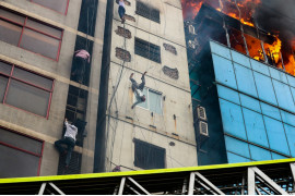 fot. Mohammad Sazid Hossain, "Death of a Fire Victim", 1. miejsce w kat. Documentary & Photojournalism / Siena International Photo Awards 2020<br></br><br></br>Pożar 22-piętrowego biurowaca w Dhace, w którym zginęło 25 osób, a kolejnych 70 zostało rannych. Mężczyzna na zdjęciu próbował schodzić po fasadzie sąsiedniego budynku. W pewnym momencie ciepło sprawiło, że puścił się kabla i spadł na ziemię. 