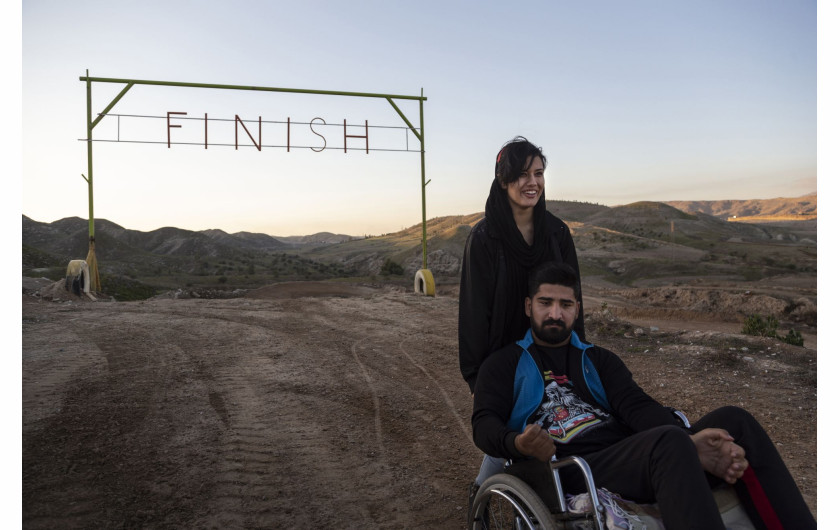 fot. Fereshteh Eslahi, Iran, Podium Photos, z cyklu: Thoughts of Flight, 3 miejsce w kategorii Sport - seria zdjęć / World Press Photo 2021

Saeed Ramin jest zawodowym traceurem (uprawiającym parkour) mieszkającym w Gachsaran w Iranie. Siedem lat temu Saeed upadł podczas zawodów w parkourze, uszkadzając rdzeń kręgowy w szyi. Celem parkour jest przedostanie się z jednego punktu do drugiego w złożonym - zazwyczaj miejskim - otoczeniu, bez pomocy sprzętu pomocniczego, w jak najszybszy i najbardziej efektywny sposób: biegając, huśtając, wspinając się i wykonując wiele innych ruchów, czasem w niebezpiecznych sytuacjach, takich jak przechodzenie między wysokimi dachami. Dyscyplina ta została spopularyzowana w późnych latach 90. i 2000 poprzez filmy, gry wideo, filmy dokumentalne i reklamy, a stała się popularna w Iranie po tym, jak dwóch irańskich traceurów pojawiło się w filmie dokumentalnym Jump London. Uraz Saeeda po upadku był tak poważny, że mógł on tylko mrugać, a lekarze powiedzieli, że nie będzie w stanie nawet usiąść na wózku inwalidzkim. Saeed nie mógł sobie pozwolić na dłuższe leczenie szpitalne, ale z pomocą rodziny zaimprowizował sprzęt rehabilitacyjny na swoim podwórku i wbrew przewidywaniom lekarzy udało mu się odzyskać sprawność rąk. Saeed odzyskał więcej swoich zdolności, a teraz jest w stanie poradzić sobie z wózkiem inwalidzkim. Nadal lubi robić rzeczy, których inni ludzie się boją.
