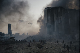 fot. 
Lorenzo Tugnoli, Włochy, Contrasto, Z cyklu: "Port Explosion in Beirut", nominacja w kategorii "Spot news - seria zdjęć"  / World Press Photo 2021<br></br><br></br>

Około godziny 18:00, 4 sierpnia, potężna eksplozja, spowodowana przez ponad 2750 ton azotanu amonu o wysokiej gęstości, wstrząsnęła stolicą Libanu, Bejrutem. Mieszanka wybuchowa była przechowywana w magazynie w porcie. W promieniu kilometra od magazynu mieszkało około 100 000 osób. Eksplozja, która miała siłę 3,3 stopnia w skali Richtera, uszkodziła lub zniszczyła około 6 tysięcy budynków, zabiła co najmniej 190 osób, zraniła kolejne 6 tysięcy, a 300 tysięcy wysiedliła. Azotan amonu pochodził ze statku, który został skonfiskowany w 2012 r. za nieuiszczenie opłat za dokowanie i innych opłat, i najwyraźniej porzucony przez właściciela. W latach 2014-2017 urzędnicy celni co najmniej sześć razy pisali do libańskich sądów z pytaniem, jak pozbyć się materiału wybuchowego. W międzyczasie był on przechowywany w magazynie w nieodpowiednim klimacie. Nie jest jasne, co spowodowało eksplozję, ale najbardziej prawdopodobną przyczyną wydaje się zanieczyszczenie innymi substancjami podczas transportu lub przechowywania. Wielu obywateli uznało ten incydent za symptom ciągłych problemów, z jakimi boryka się kraj, a mianowicie nieudolności rządu, niegospodarności i korupcji. W kilka dni po wybuchu dziesiątki tysięcy demonstrantów wypełniły ulice centrum Bejrutu, niektórzy starli się z siłami bezpieczeństwa i zajęli budynki rządowe, protestując przeciwko systemowi politycznemu, który ich zdaniem nie chce rozwiązać problemów kraju.